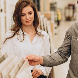 Young couple choosing tiles at building market
